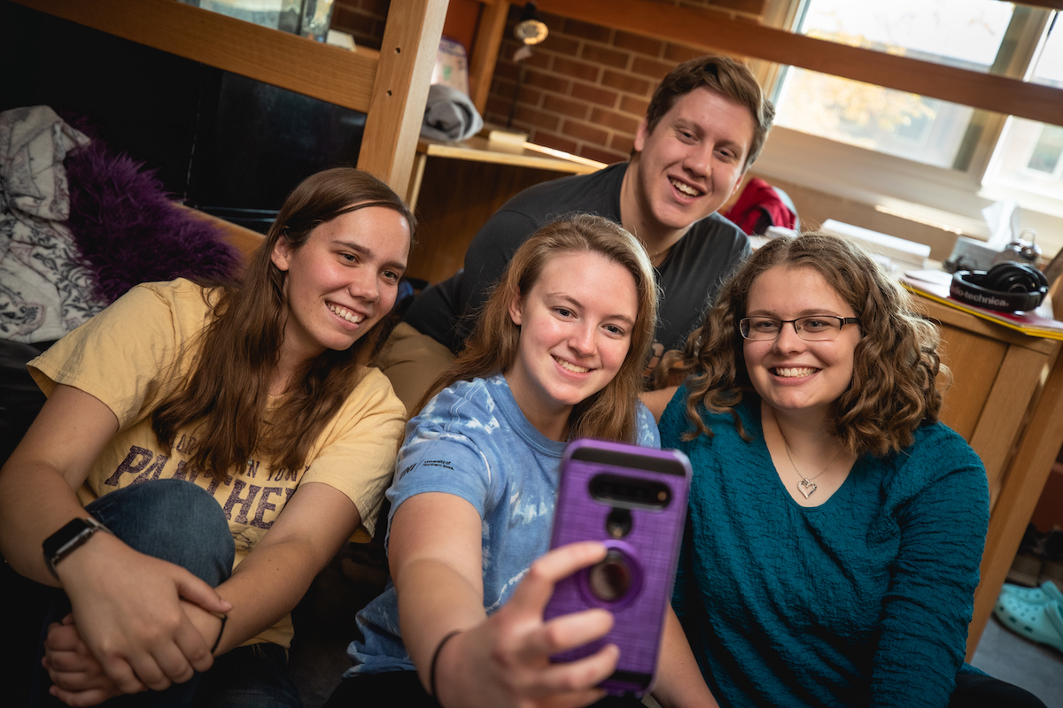 Students taking a selfie in a dorm